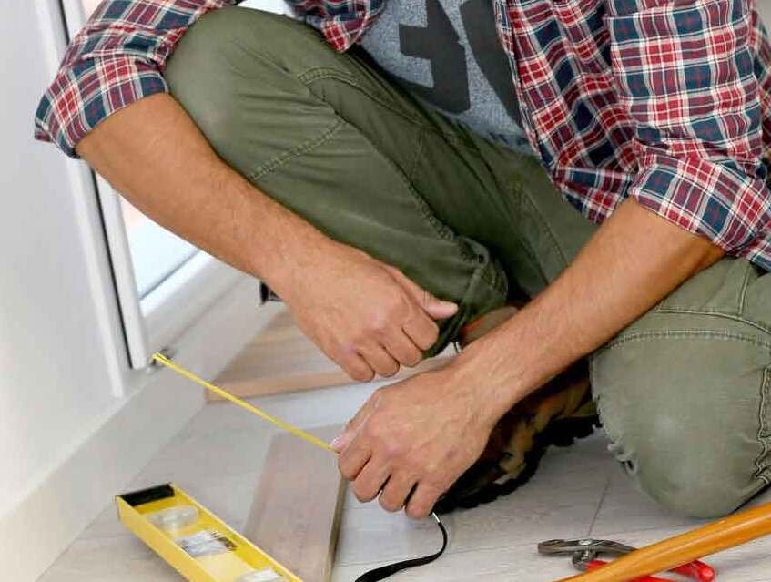 man installing flooring